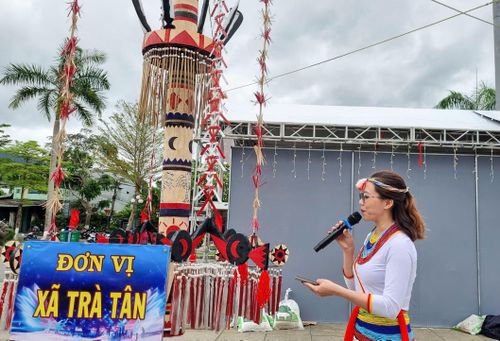  Cô gái Cor trong trang phục truyền thống giới thiệu về cây nêu của xã Trà Tân. Ảnh: NGUYỄN TRANG 