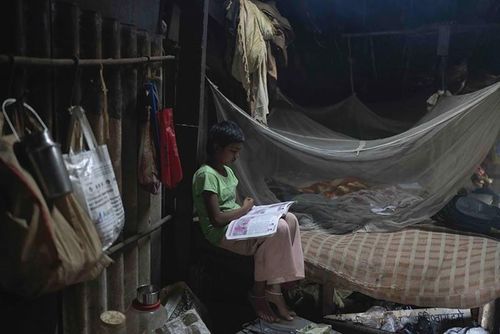 Neelam Krishan, 11 tuổi, học tại nhà ở Thane gần Mumbai, Ấn Độ. Ảnh: AP. Vào buổi tối, học sinh như Krishan sẽ trở về nhà ở vùng ngoại ô của thành phố, nhiều ngôi nhà được dựng tạm từ những tấm tôn, ván ép và bạt che.