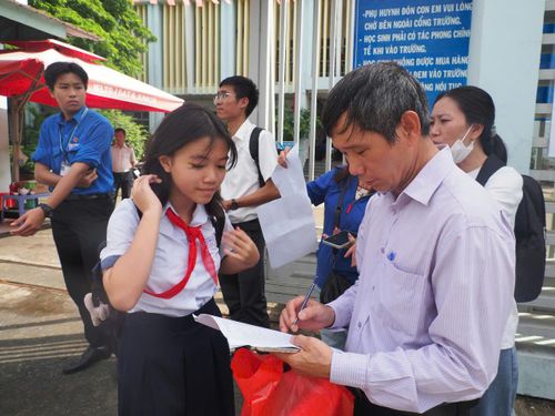 Giáo viên Trường THCS Bình Quới Tây điểm danh học sinh trước giờ vào làm thủ tục dự thi