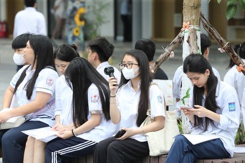 Một số thí sinh ngồi chờ dưới sân trường