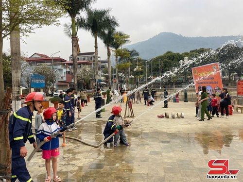 Nhân dân và các em nhỏ xã Thuận Châu tham gia trải nghiệm thực hành PCCC. 