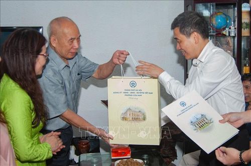 Lãnh đạo phường Cửa Nam (TP Hà Nội) thăm hỏi, động viên trao quà tặng thương binh Nguyễn Công Hòa. Ảnh: Vũ Quang/TTXVN