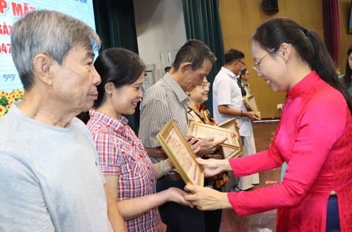 Các gia đình tại phường Phú Nhuận nhận giấy công nhận “Gia đình cách mạng gương mẫu”. Ảnh: THÁI PHƯƠNG