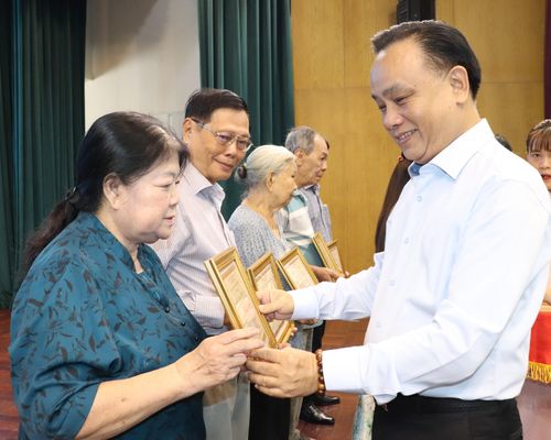 Bí thư Đảng ủy, Chủ tịch HĐND phường Phú Nhuận Nguyễn Đông Tùng trao giấy công nhận “Gia đình cách mạng gương mẫu” đến các gia đình. Ảnh: THÁI PHƯƠNG