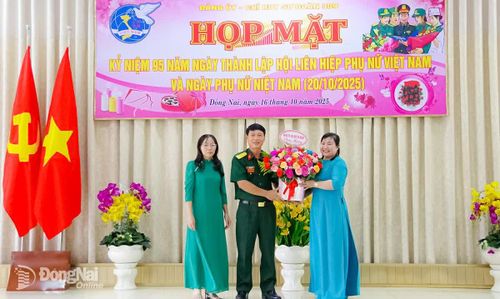 Đại tá Phùng Thế Hùng, Phó Tham mưu trưởng Quân khu 7 tặng hoa chúc mừng cán bộ, hội viên phụ nữ cơ quan Sư đoàn 309 trong buổi họp mặt. Ảnh: Hùng Ân