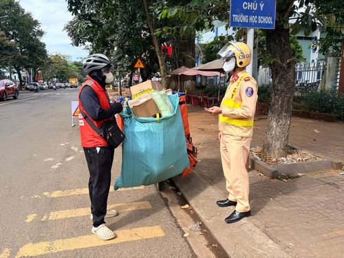 Một shipper chở hàng hóa che khuất BKS xe bị lực lượng CSGT kiểm tra. Ảnh: Văn Ngọc