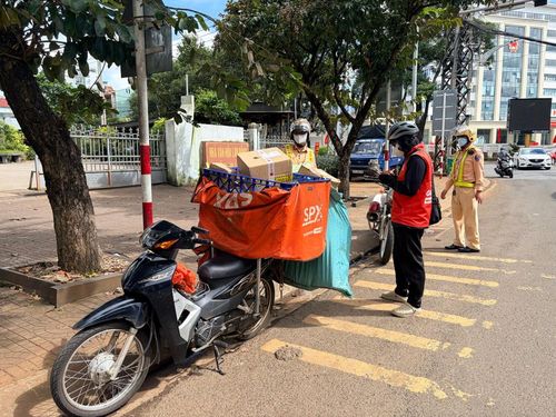 Lực lượng CSGT tập trung xử lý các lỗi vi phạm của shipper. Ảnh: Văn Ngọc