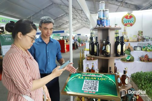 Người tiêu dùng sử dụng điện thoại thông minh để quét mã tìm hiểu thông tin về nông sản địa phương. Ảnh: Bình Nguyên