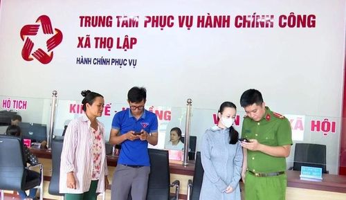 Cán bộ, đoàn viên thanh niên xã Thọ Lập hỗ trợ, hướng dẫn người dân sử dụng các dịch vụ ứng dụng trên điện thoại thông minh khi đến làm việc tại Trung tâm Phục vụ hành chính công xã.