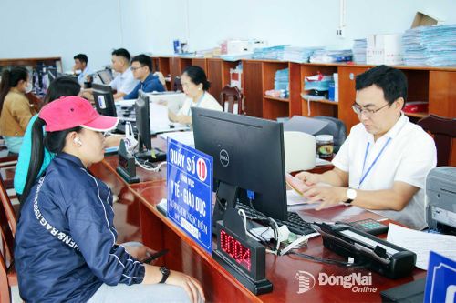 Chuyên viên Trung tâm Phục vụ hành chính công xã Đại Phước hướng dẫn, hỗ trợ người dân thực hiện các thủ tục hành chính trực tuyến. Ảnh: Hải Quân