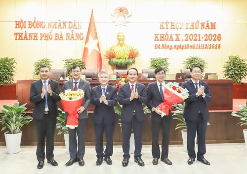 Lãnh đạo thành phố tặng hoa chúc mừng ông Trần Thắng Lợi (thứ 2, bên phải sang) được bầu vào chức danh Ủy viên UBND thành phố, tặng hoa ghi nhận những đóng góp của ông Phan Văn Bình, Chánh Văn phòng Thành ủy, nguyên Giám đốc Sở Nội vụ (thứ 2, bên trái sang). Ảnh PV