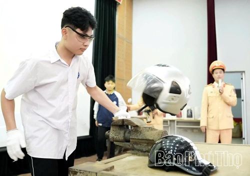 Học sinh được cán bộ Đội Cảnh sát giao thông đường bộ số 3 trực tiếp hướng dẫn cách lựa chọn mũ bảo hiểm xe máy đảm bảo an toàn.