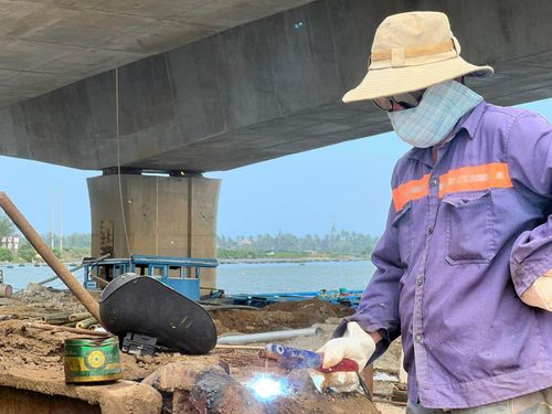 Công nhân khẩn trương hoàn thiện các hạng mục trên cầu Tam Tiến. Ảnh: XUÂN SƠN