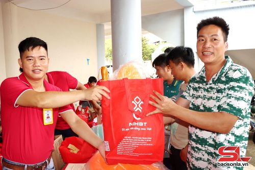 Tình nguyện viên chữ thập đỏ tặng quà cho người tham gia hiến máu. 