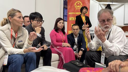 Ông Bob Kirke, Giám đốc Liên đoàn dệt may Canada (phải), trao đổi với đại diện đoàn dệt may Việt Nam dự sự kiện.