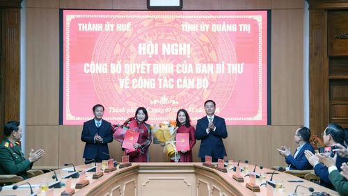 Đồng chí Nguyễn Đình Trung, Bí thư Thành ủy Huế và đồng chí Nguyễn Văn Phương, Bí thư Tỉnh ủy Quảng Trị trao quyết định và tặng hoa chúc mừng đồng chí Hồ Thị Thu Hằng và đồng chí Phạm Thị Minh Huệ - Ảnh: Q.V