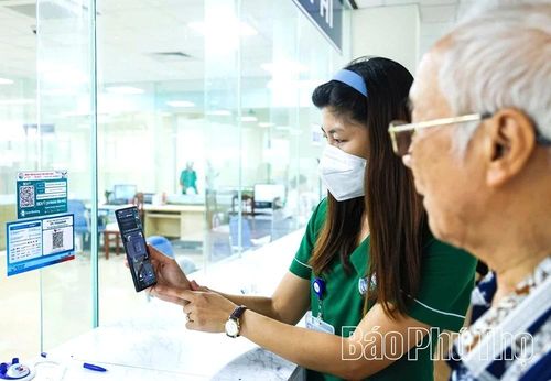 Cán bộ Bệnh viện Đa khoa Vĩnh Phúc hướng dẫn người dân quét mã QR để thanh toán viện phí trực tuyến.