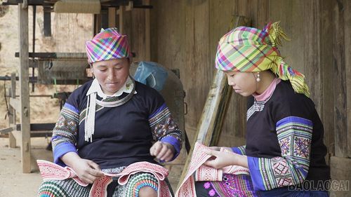  Bà Lờ Thị Mò hướng dẫn con dâu thêu họa tiết hoa văn trên váy, áo. 