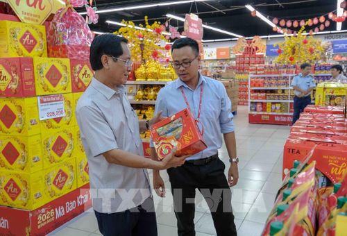Phó Giám đốc Sở Công Thương thành phố Cần Thơ Huỳnh Thanh Sử kiểm tra hàng hóa phục vụ Tết nguyên đán Bính Ngọ ở siêu thị Lotte Mart Cần Thơ. Ảnh: Thanh Liêm - TTXVN