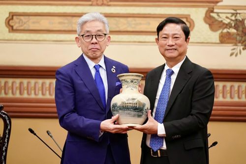 Chủ tịch HĐND TPHCM Võ Văn Minh tặng bình gốm sứ biểu tượng UBND TPHCM cho ông Fujiwara Hirohisa, Phó Tổng Giám đốc Tập đoàn Tokyu. Ảnh: HOÀNG HÙNG