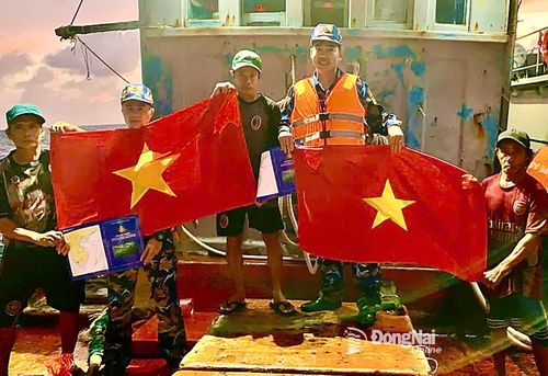 Cán bộ, chiến sĩ Vùng 2 Hải quân tuyên truyền và tặng cờ Tổ quốc cho các ngư dân trên biển. Ảnh: Văn Đường