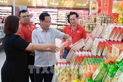 Phó Giám đốc Sở Công Thương Cần Thơ Huỳnh Thanh Sử kiểm tra mặt hàng bánh kẹo Tết bày bán ở siêu thị GO! Cần Thơ. Ảnh: Thanh Liêm - TTXVN
