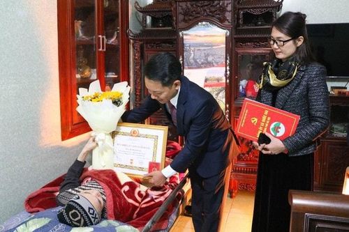 Phó Bí thư Thường trực Đảng ủy Phùng Văn Tài đã đến tư gia để trao Huy hiệu Đảng tặng các đảng viên cao tuổi Đảng, sức yếu. Ảnh: Bích Liên