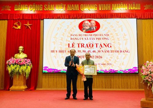 Lãnh đạo xã Tây Phương trao Huy hiệu Đảng tặng các đảng viên. Ảnh: Nguyễn Hằng