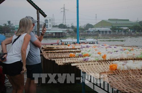 Du khách nước ngoài thích thú "check in" chợ nổi từ trên cao. Ảnh: Nguyễn Hằng - TTXVN