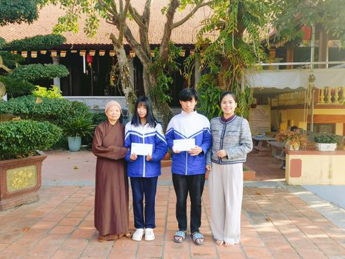 Chủ tịch Hội LHPN phường và đại diện Chùa Tăng Phúc trao quà cho trẻ mồ côi