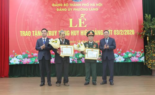 Phó Bí thư Thường trực Thành ủy Nguyễn Văn Phong và lãnh đạo phường Láng trao Huy hiệu Đảng và tặng hoa chúc mừng các đảng viên lão thành.