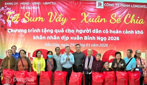 Tỉnh ủy viên, Bí thư Đảng ủy, Chủ tịch HĐND xã Dầu Giây Cao Tiến Sỹ cùng đại diện Ban Giám đốc Công ty TNHH Long Well trao quà tại chương trình. Ảnh: Nhật Quang