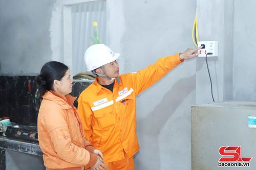 Công nhân Đội quản lý Điện lực khu vực Bắc Yên - Phù Yên hướng dẫn nhân dân xã Gia Phù sử dụng điện an toàn. 