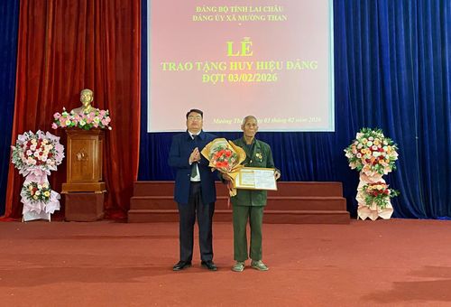Đồng chí Tao Văn Giót - Bí thư Đảng ủy, Chủ tịch HĐND xã Mường Than trao Huy hiệu 45 năm tuổi Đảng cho đảng viên Lò Văn Kha - Chi bộ bản Sân Bay.