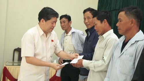 Phó Chủ nhiệm Ủy ban Văn hóa và Xã hội của Quốc hội Tạ Văn Hạ tặng quà cho người dân xã Thăng Phú. Ảnh: TRUNG THỰC