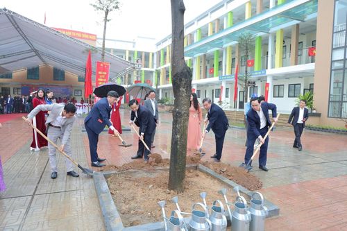 Chi cục trưởng Chi cục Chăn nuôi, Thủy sản và Thú y Hà Nội Nguyễn Đình Đảng và lãnh đạo xã Phú Nghĩa trồng cây xanh tại Trường THCS Trung Hòa sáng 22-2. Ảnh: Kim Thoa