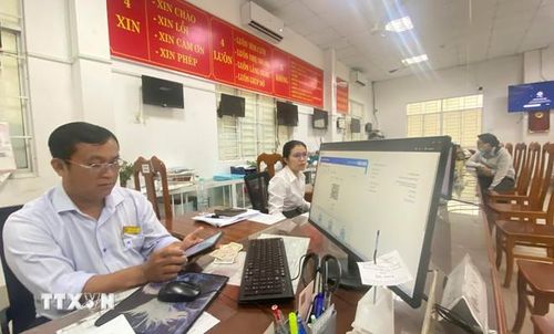  Cán bộ Trung tâm Phục vụ hành chính công phường Long Xuyên (tỉnh An Giang) hỗ trợ người dân thực hiện thủ tục hành chính công trên môi trường số. (Ảnh: Công Mạo/TTXVN) 