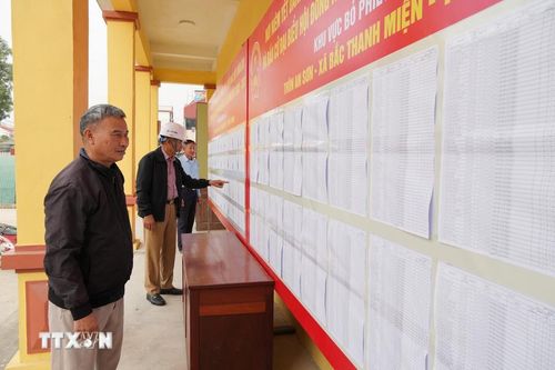 Các cử tri xem danh sách niêm yết tại khu vực bỏ phiếu xã Bắc Thanh Miện, TP Hải Phòng. Ảnh: Tiến Vĩnh/TTXVN