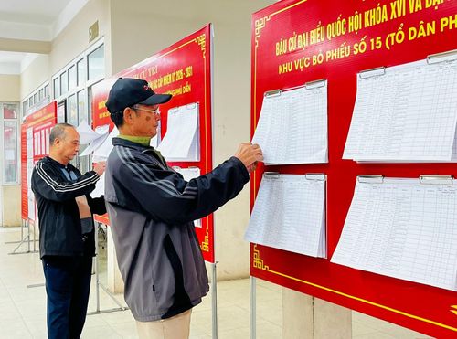 Các cử tri xem danh sách cử tri niêm yết tại đơn vị bầu cử số 4 phường Phú Diễn. Ảnh: Nam Du