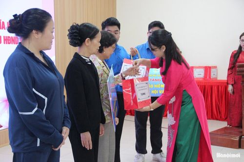 Chủ tịch Hội Liên hiệp phụ nữ phường Tương Mai Trần Thị Thúy Hằng trao quà và thẻ BHYT cho hội viên phụ nữ có hoàn cảnh khó khăn. Ảnh: T.H