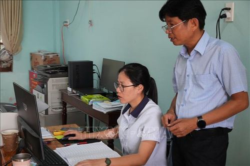 Cán bộ Ủy ban bầu cử xã Tân Hiệp tiếp tục rà soát danh sách cử tri trên địa bàn xã. Ảnh: Đỗ Trưởng/TTXVN