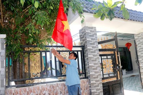 Người dân treo cờ chào mừng ngày hội lớn