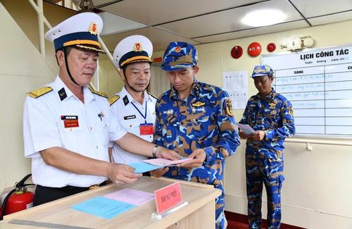 Cử tri nhận phiếu bầu cử sớm trên tàu. (Ảnh do Vùng 5 Hải quân cung cấp)