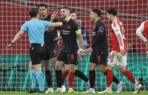 Các cầu thủ Bayer Leverkusen phản ứng dữ dội quyết định của trọng tài.