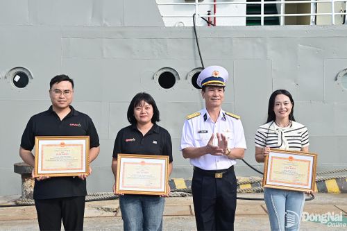 Phó Chính ủy Vùng 2 Hải quân tặng giấy khen cho các phóng viên tham gia thực hiện nhiệm vụ tuyên truyền. Ảnh: Đức Việt