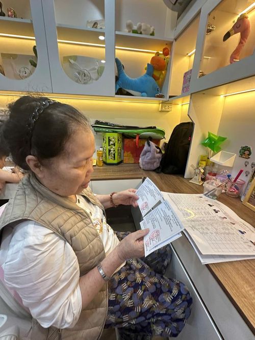 Bà Phạm Thị Lý cầm trên tay thẻ cử tri, dành thời gian tìm hiểu kỹ thông tin các ứng cử viên trước ngày bầu cử.