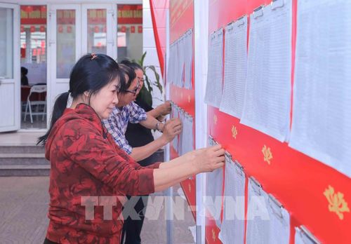 Cán bộ Tổ bầu cử khu vực bỏ phiếu số 22, đơn vị bầu cử số 5, phường Việt Hưng, TP Hà Nội, niêm yết danh sách người ứng cử trước điểm bầu cử. Ảnh: Phan Phương – TTXVN