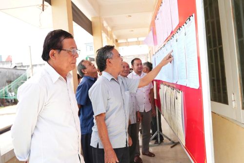 Cử tri là giáo dân tìm hiểu thông tin các ứng viên niêm yết tại khu vực bầu cử