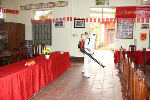 Lực lượng chức năng xã Quảng Bị thực hiện khử trùng các địa điểm bỏ phiếu trước kỳ bầu cử. Ảnh: Minh Thân