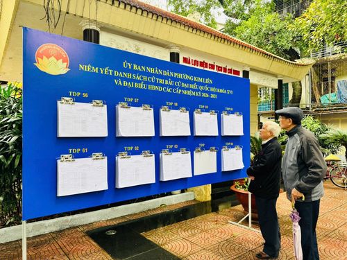 Người dân phường Kim Liên theo dõi danh sách cử tri chuẩn bị cho ngày bầu cử diễn ra 15-3. Ảnh: PV